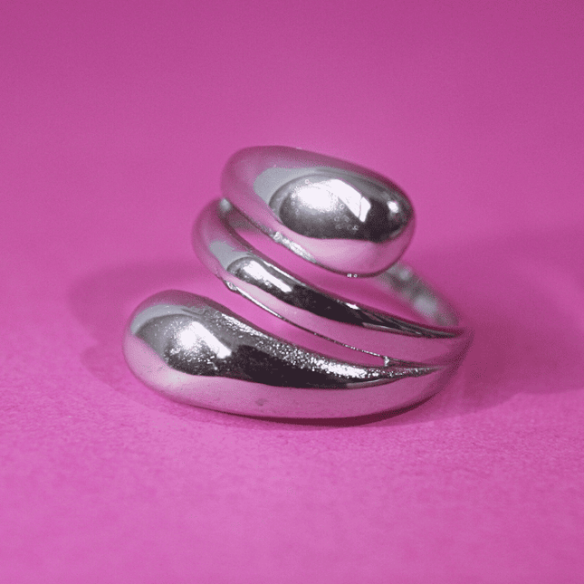 Anillo enrollado moderno plateado, diseño elegante y contemporáneo en acero inoxidable.