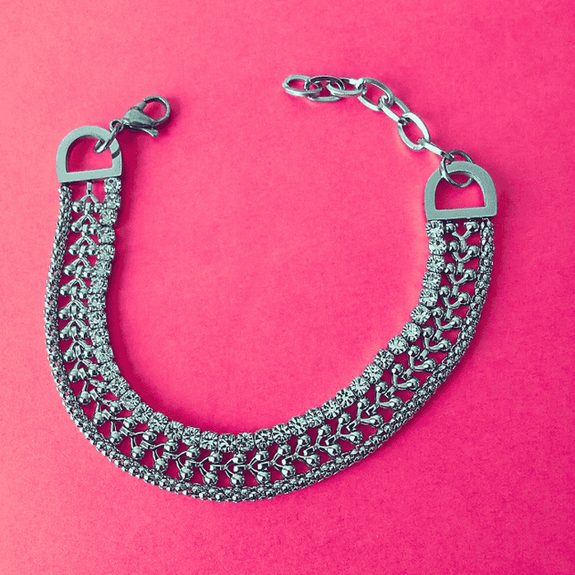Pulsera plateada de acero inoxidable con tres hileras: circonitas brillantes, trenzado y diseño de cerezas. Joya llamativa y sofisticada.