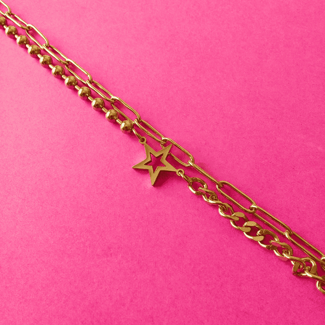 Estrella hueca en pulsera dorada de acero inoxidable. Detalle central con actitud.