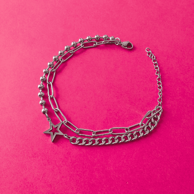 Pulsera plateada con estrella hueca central, mezcla de eslabones y bolitas. Diseño de acero inoxidable con estilo atrevido.