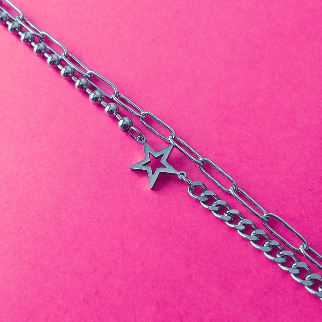 Estrella hueca en el centro de pulsera plateada. Pieza con actitud y diseño único.