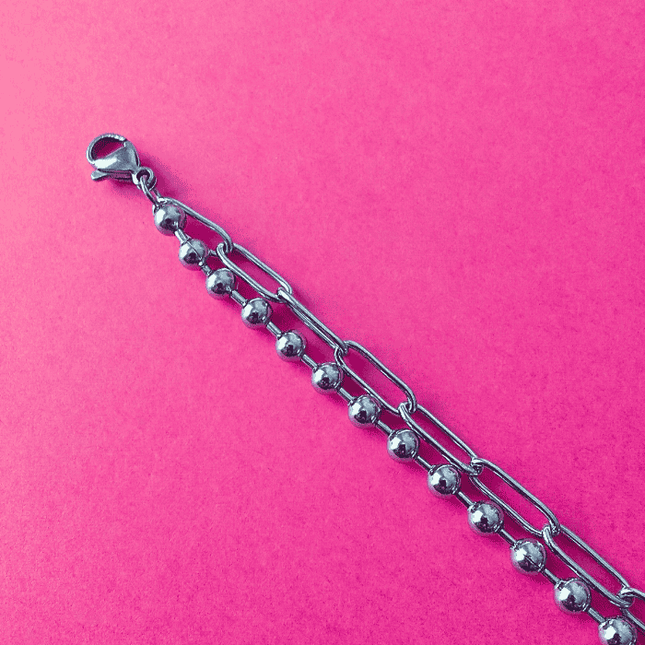 Cierre de mosquetón en pulsera de acero inoxidable plateada. Seguridad y presencia.