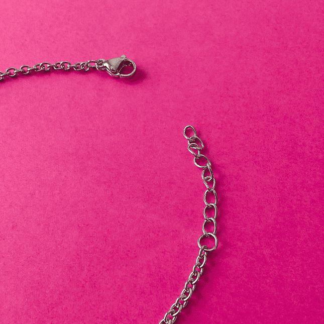Cierre de mosquetón en pulsera de acero inoxidable plateada. Toque resistente con acabado brillante.